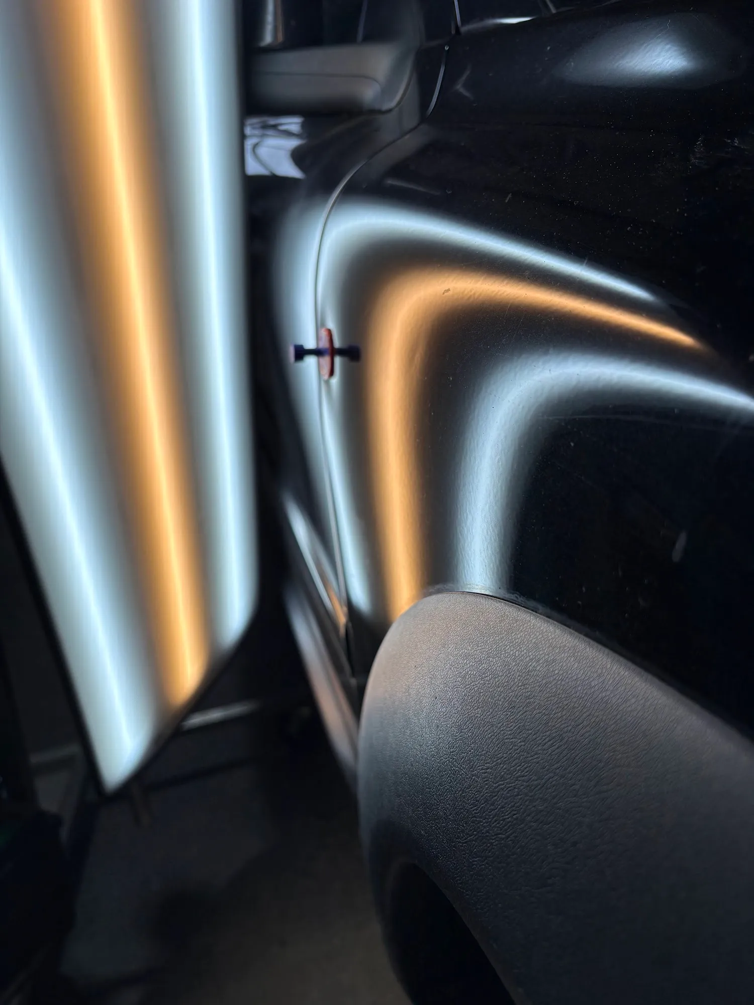 Feinmechanische Ausbeultechnik mit Klebe-Zugadapter und PDR-Lampe am Fahrzeug